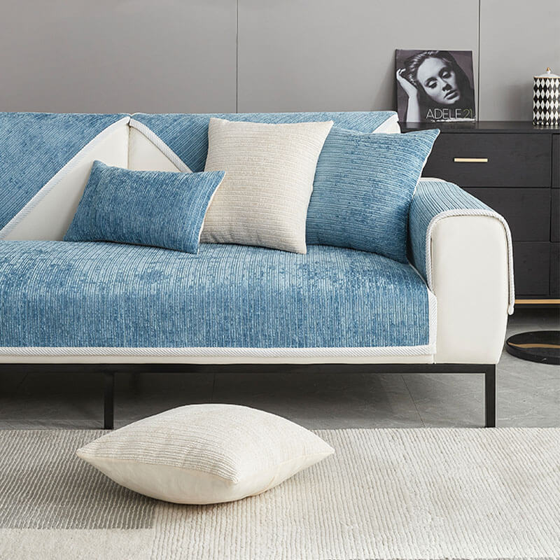 Front view of a blue ribbed cover on a cream sofa with matching cushions and a cream floor cushion. 11