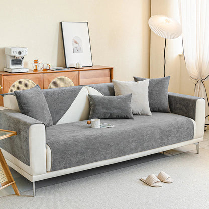 Full grey chenille cover on a cream three-seater sofa in a bright living room with cushions, a mug and slippers. 13