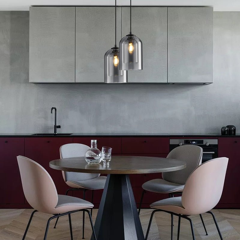 Two smoked glass pendants hanging over a round dining table in a kitchen with burgundy cabinets 7