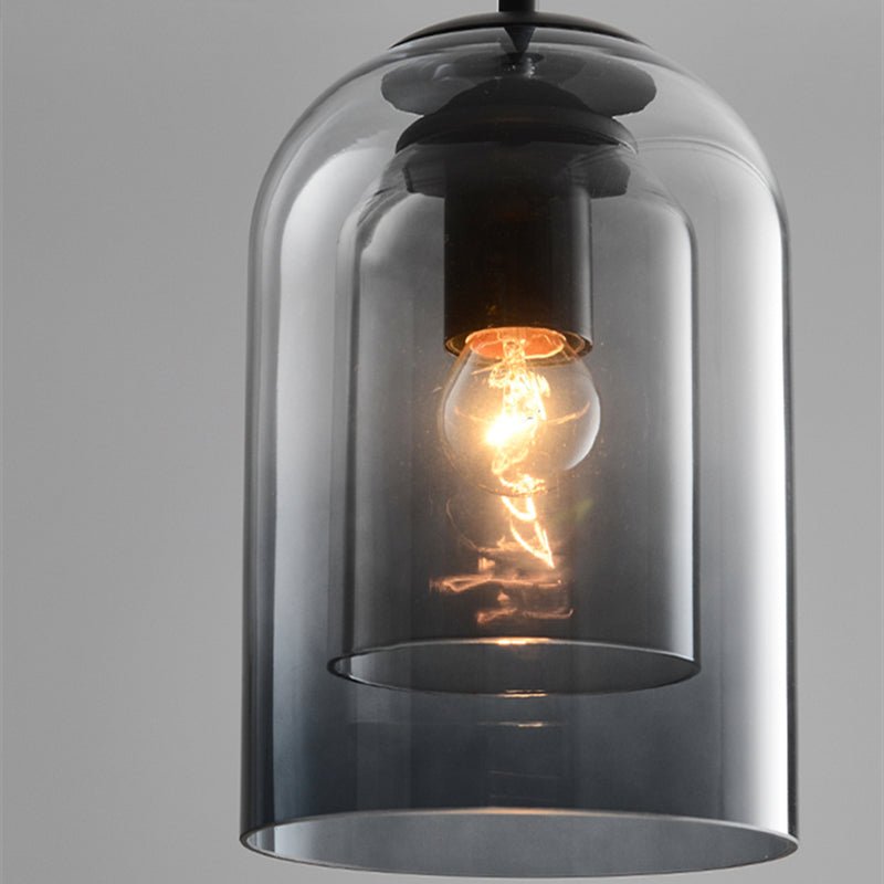 Close-up of the smoked grey double glass shade, showing the lit filament bulb and black socket inside 8