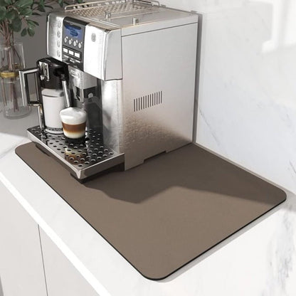 Plain taupe brown mat under a silver coffee machine with a latte in the drip tray, on a marble counter. 3