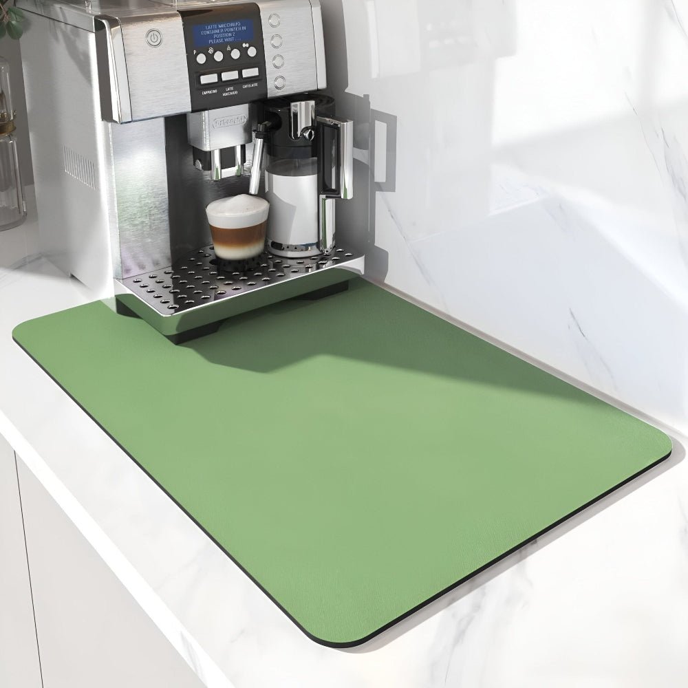 Plain sage green mat extending in front of a silver coffee machine with a latte, on a white marble worktop. 6