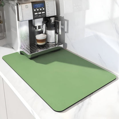 Plain sage green mat extending in front of a silver coffee machine with a latte, on a white marble worktop. 6