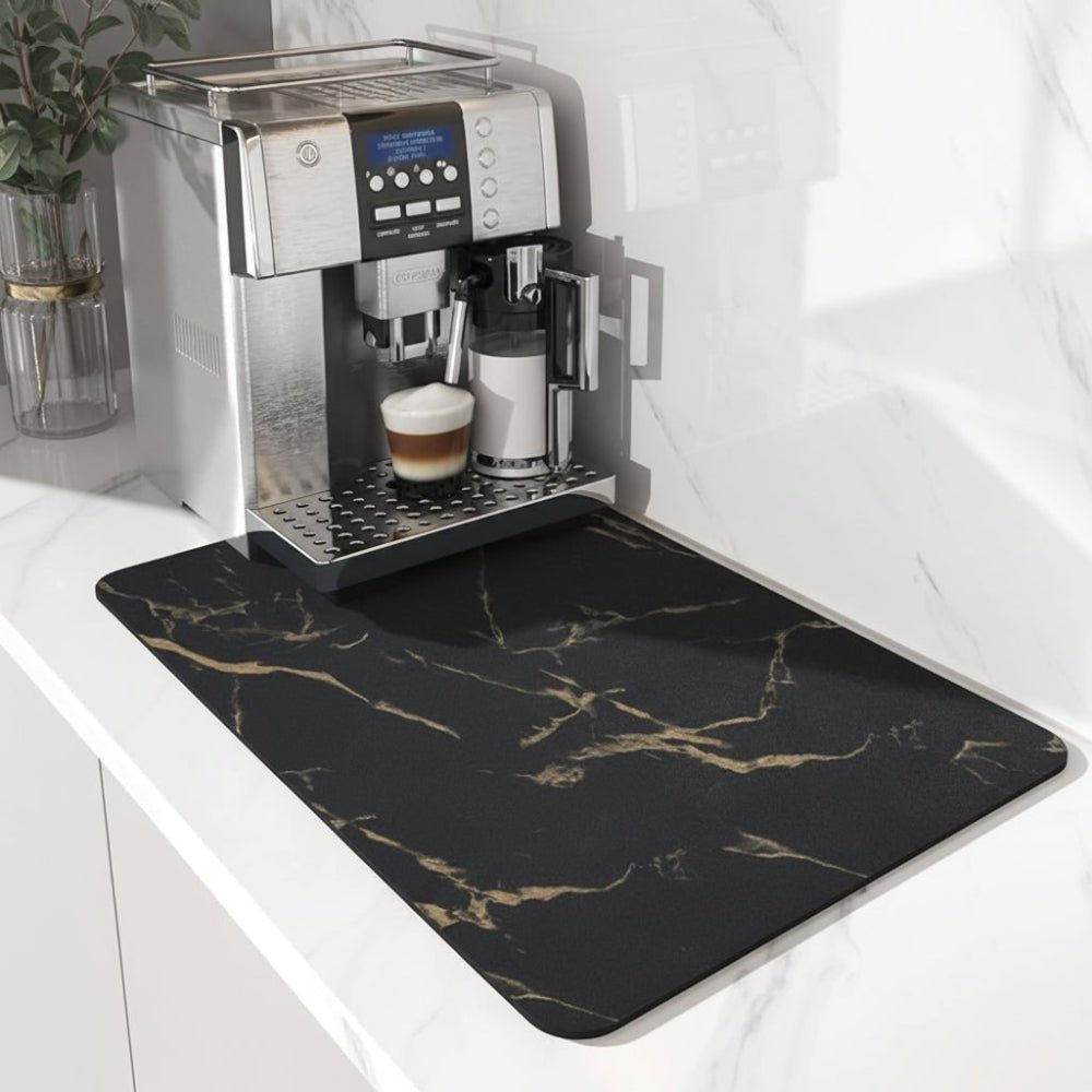 Black marble-effect mat with gold veining, laid under a silver coffee machine on a white marble counter. 5