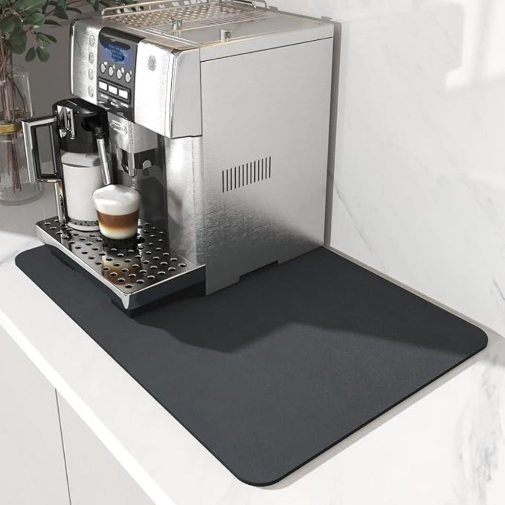 Plain charcoal black mat with rounded corners under a silver coffee machine, set on a white marble kitchen counter. 2