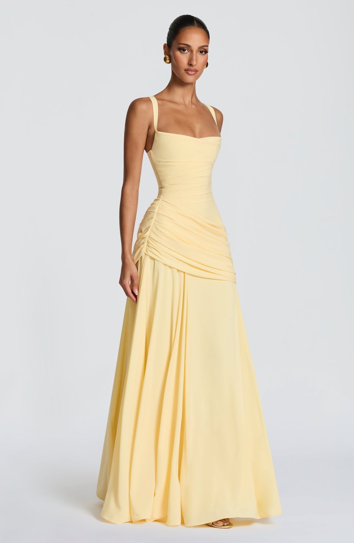 Three-quarter front view of the pale yellow dress on a model, showing the sweetheart neckline, gathered waist and full flowing skirt. 3