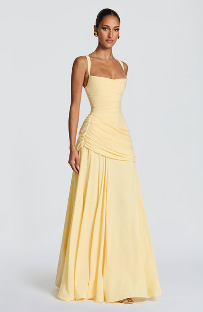 Three-quarter front view of the pale yellow dress on a model, showing the sweetheart neckline, gathered waist and full flowing skirt. 3