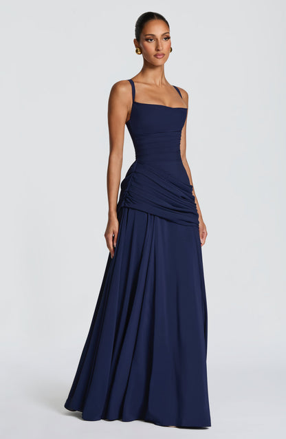 Navy dress on a model at an angle, showing ruched side gathering and the full chiffon skirt. 10