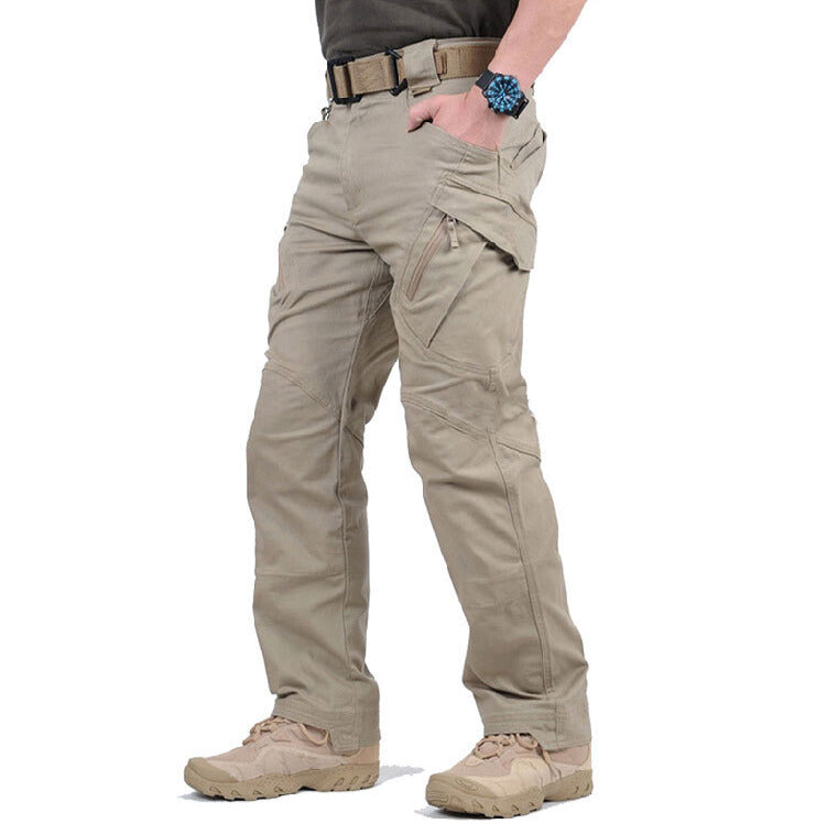 Side view of the sand-coloured trousers on a model, showing the angled zipped thigh pocket and tactical belt 3