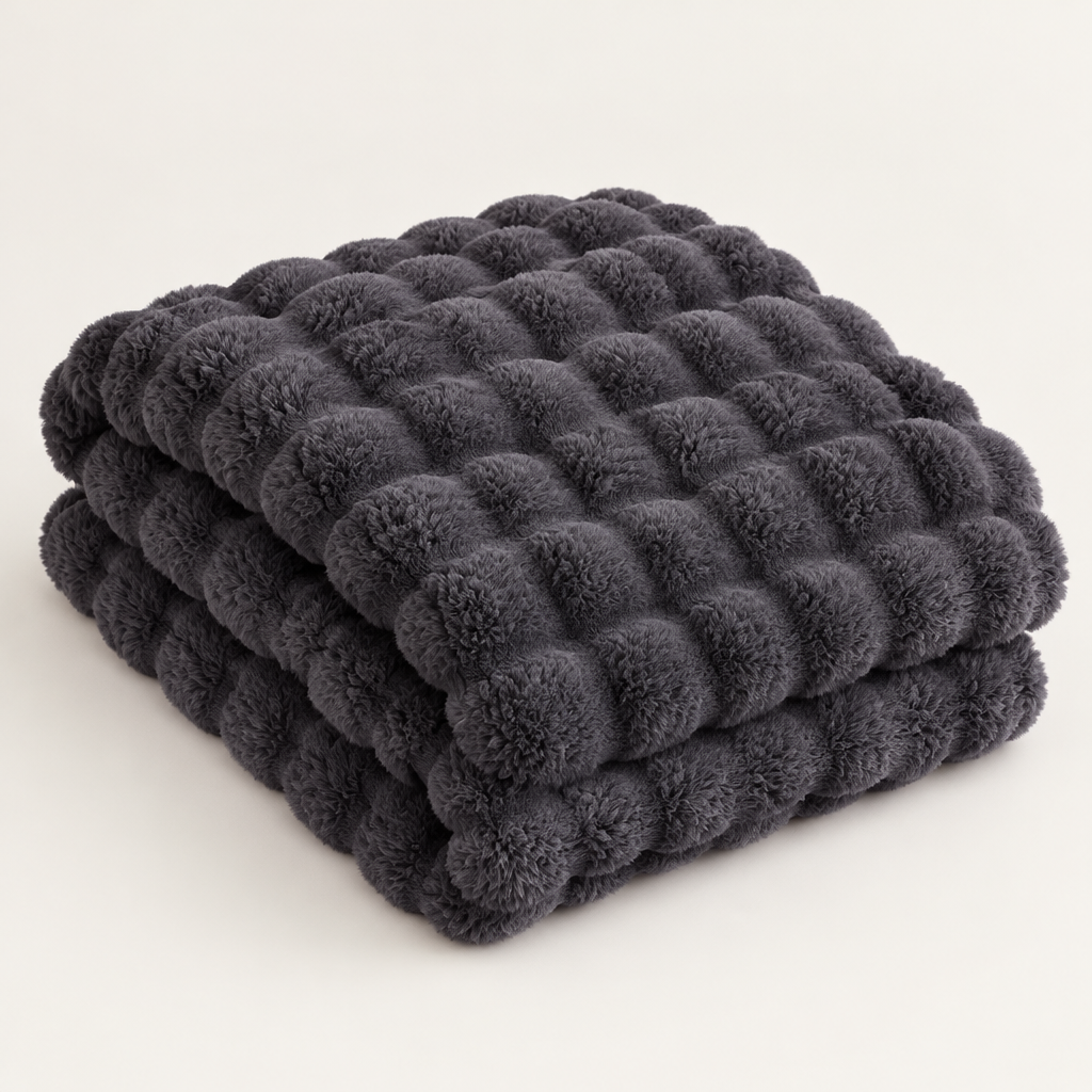 Dark grey plush blanket folded in a stack, showing its raised bubble texture against a plain background 14