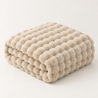 Beige plush blanket folded into a stack, showing its raised bubble texture against a plain background 13