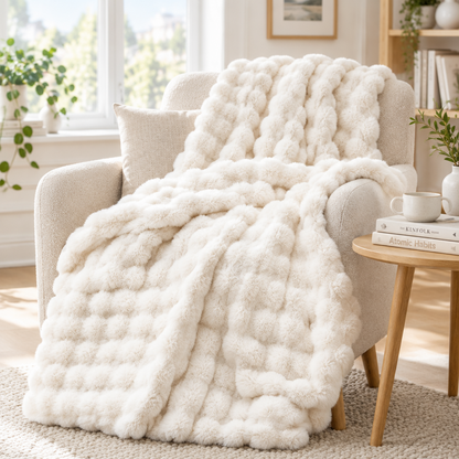 Cream white bubble-textured throw draped over an armchair with a cushion beside a wooden side table 16