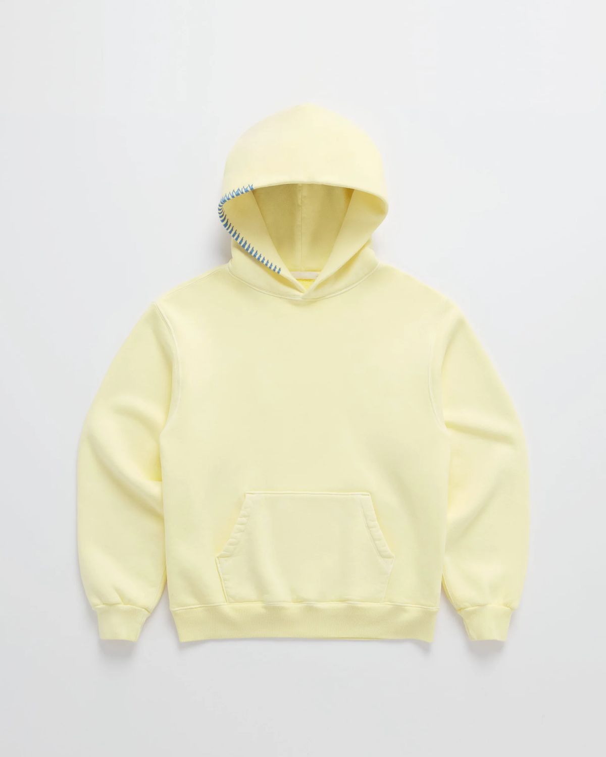 Flat lay of the pale yellow hoodie with a kangaroo pocket, ribbed cuffs and contrasting blue stitching along the hood edge. 1