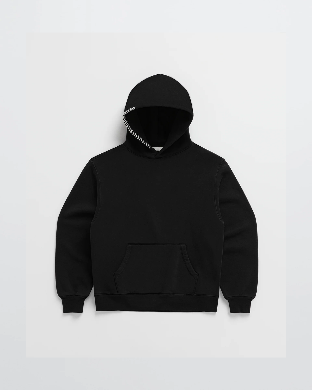 Flat lay of the black hoodie with a kangaroo pocket and white stitching along the edge of the hood. 5