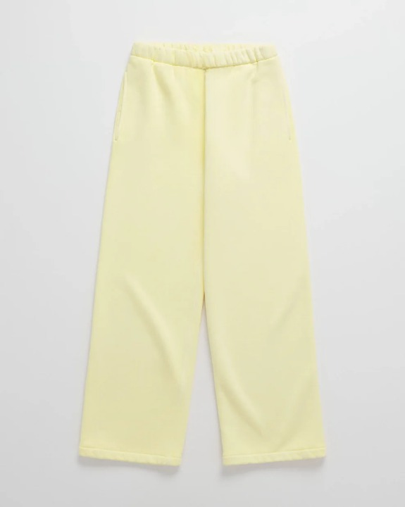Flat lay of pale yellow loose-fitting joggers with an elasticated waistband and side pockets, matching the hoodie. 6