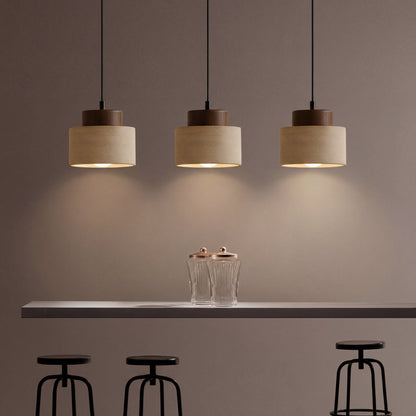 Three pendants with visible bulbs cast pools of light above a counter, glass jars and black stools 5