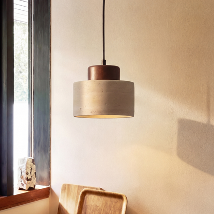 Single pendant light with dark wood cap glowing warmly beside a sunlit window and wooden trays 2