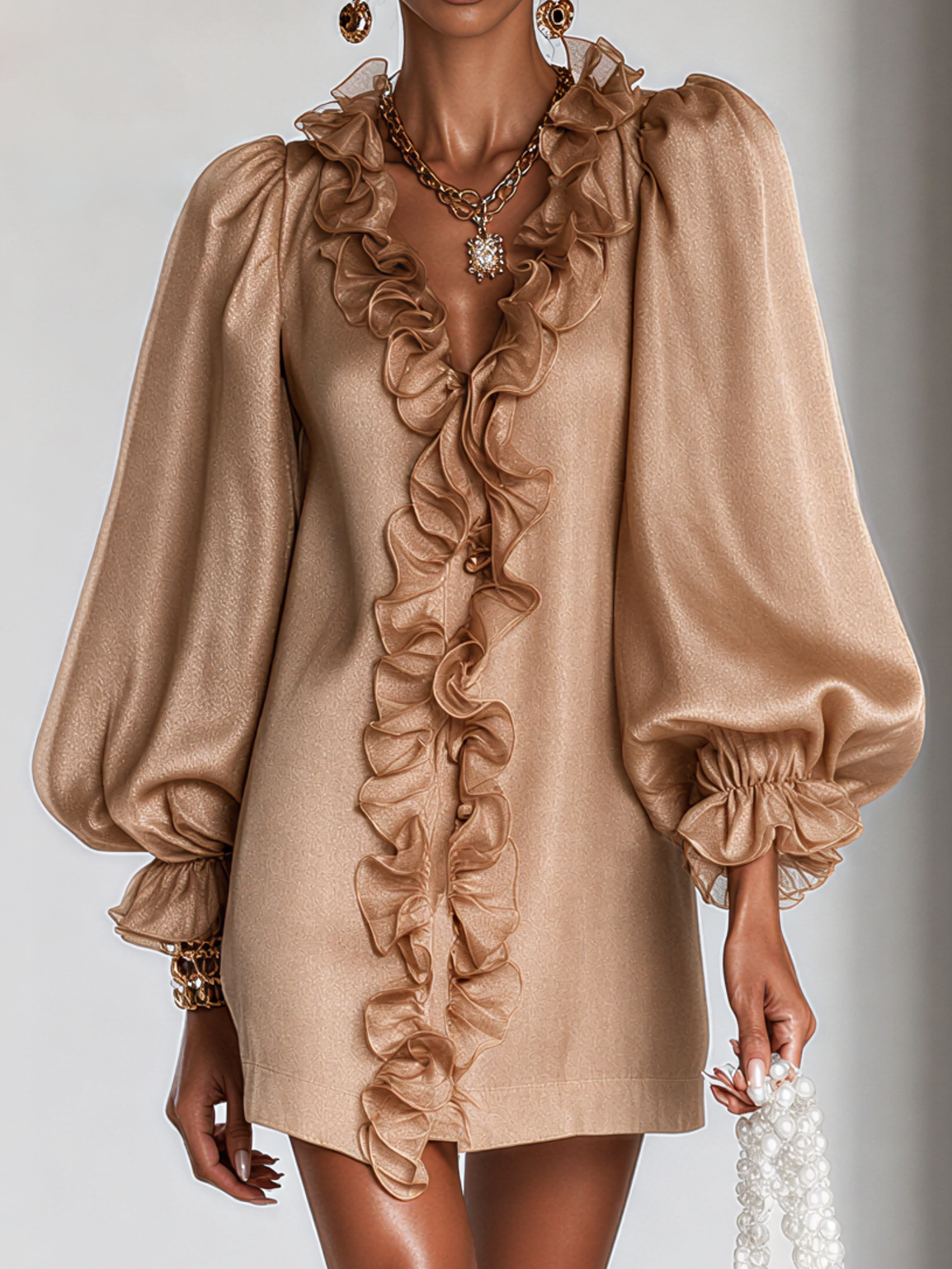 Close-up crop of the camel dress on a model, showing the ruffled V-neckline, shimmery fabric and ruffled cuffs of the puff sleeves. 4
