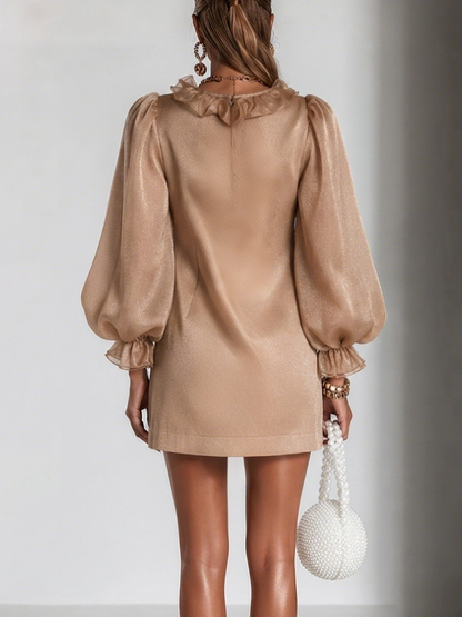 Back view of the camel dress on a model, showing the small ruffled collar, plain back, zip and gathered, ruffled sleeve cuffs. 5