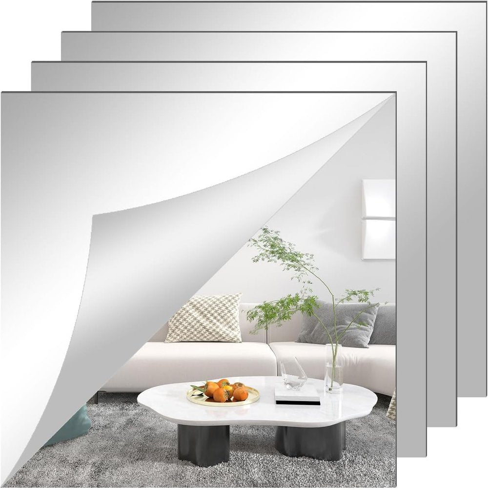 Four square mirror sheets stacked and offset, the front one peeling at the corner to reflect a sofa and coffee table. 3
