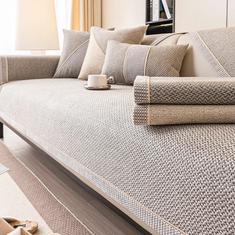 Two folded covers, one grey and one sandy beige, stacked on a sofa seat covered in grey-beige weave. 6
