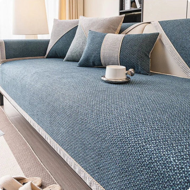 Deep blue woven sofa cover with pale braided edging, shown with grey and blue cushions and a white cup. 8