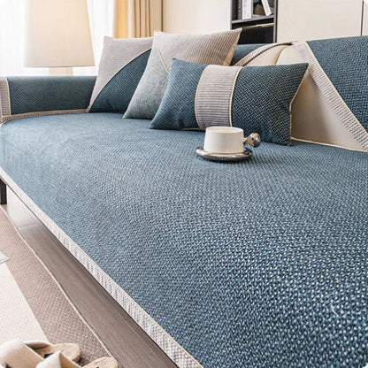 Deep blue woven sofa cover with pale braided edging, shown with grey and blue cushions and a white cup. 8