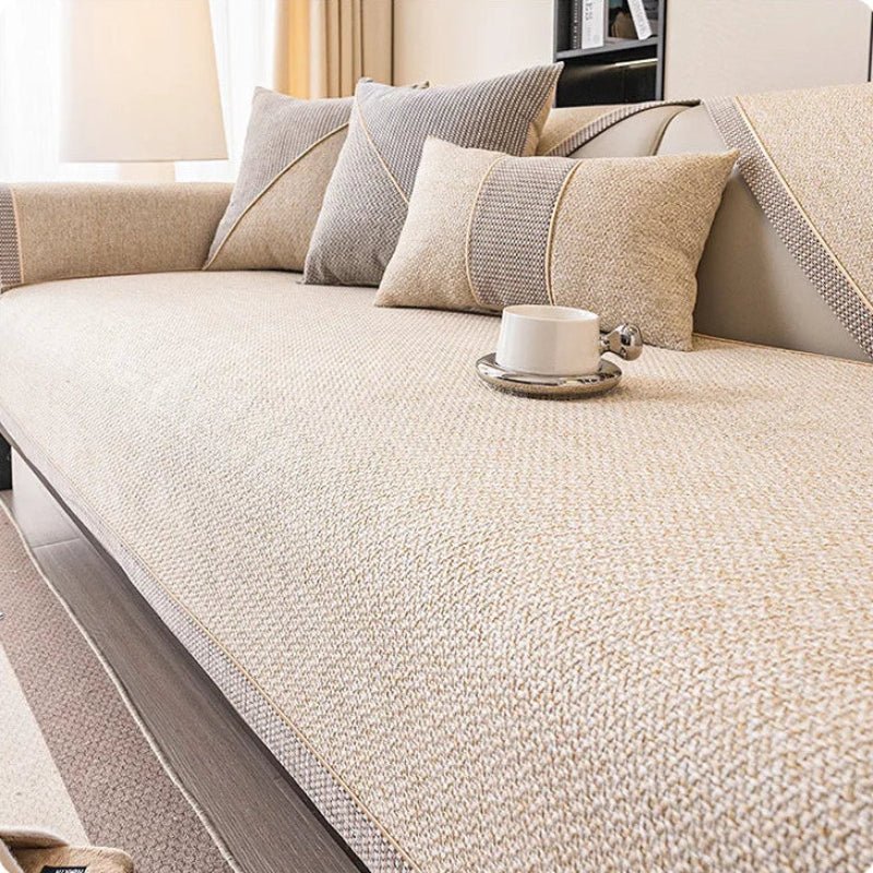 Light cream-beige woven sofa cover with braided trim, styled with grey and beige cushions and a white cup. 9