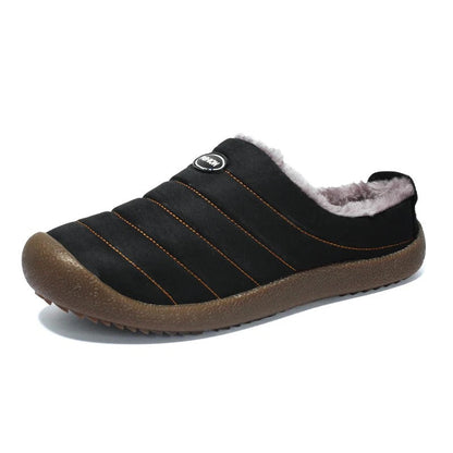 Single black quilted slipper with orange stitching, grey lining and brown sole, on white 16