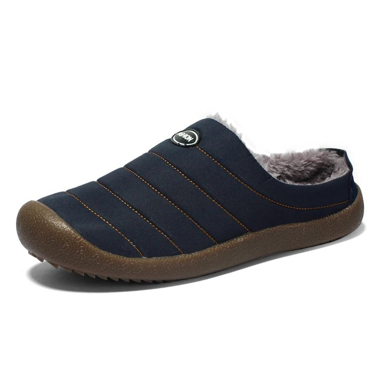 Single navy blue quilted slipper with orange stitching and brown sole, on a white background 15
