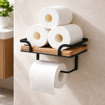 Shelf stacked with three spare toilet rolls, with a fourth roll on the black bar underneath, against a beige tiled wall. 4
