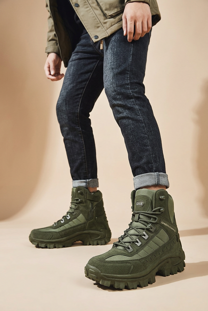 Model in dark jeans and a khaki jacket wearing olive green lace-up boots against a beige backdrop 1