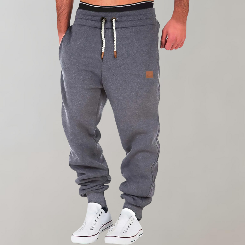 Grey marl joggers on a model with white trainers, showing drawstring and ribbed cuffs 2