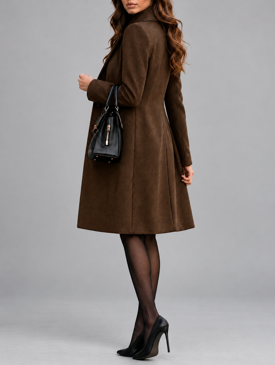 Brown coat seen from the side and back, model glancing over her shoulder with a handbag on her arm 10