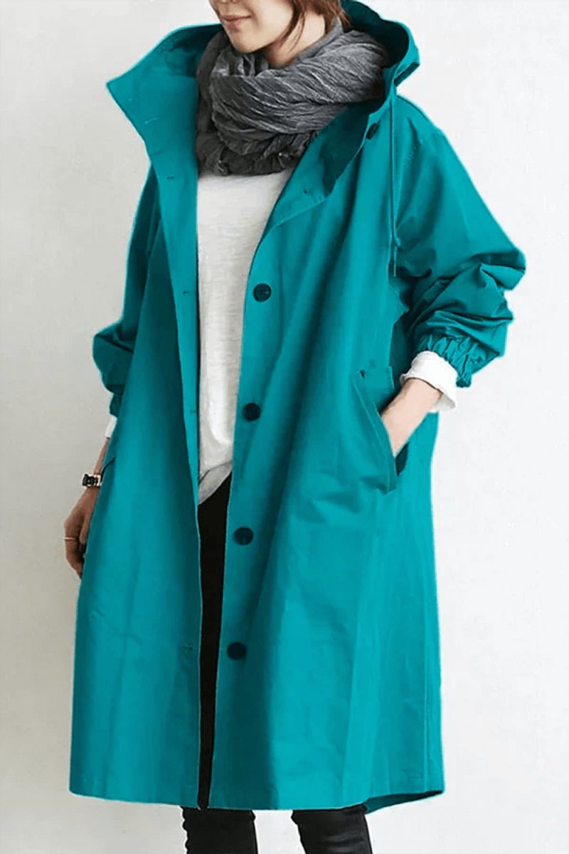 Front view of the long hooded coat in bright teal, worn open over a white top 2