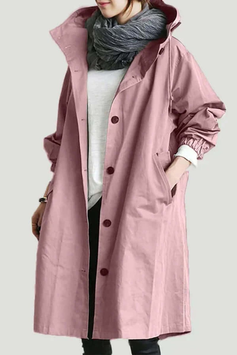 Model wearing the long buttoned hooded coat in dusky pink, with grey scarf and hand in pocket 1