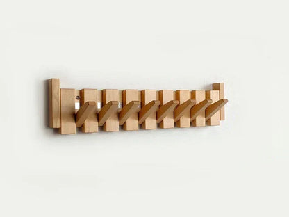 Light natural wood rack on a white wall with all hooks folded out diagonally 7