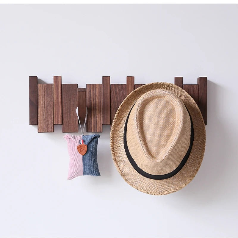 Dark walnut rack with a straw hat on one hook and a small pink and blue pouch 4