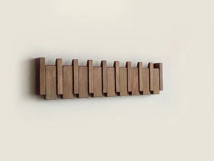 Dark wood rack with all hooks folded flat, forming a stepped piano-key pattern on the wall 8