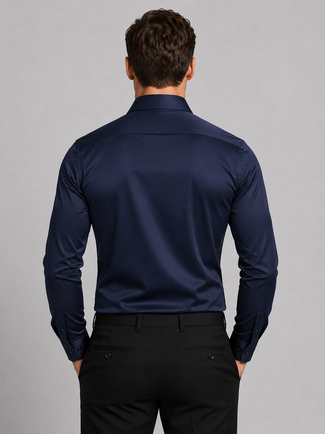 Back view of a model wearing the navy shirt with black trousers, showing the plain back yoke and buttoned cuffs. 6