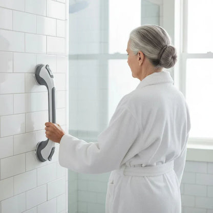 Woman in a white bathrobe holds the grab bar fitted vertically on a white tiled shower wall. 3