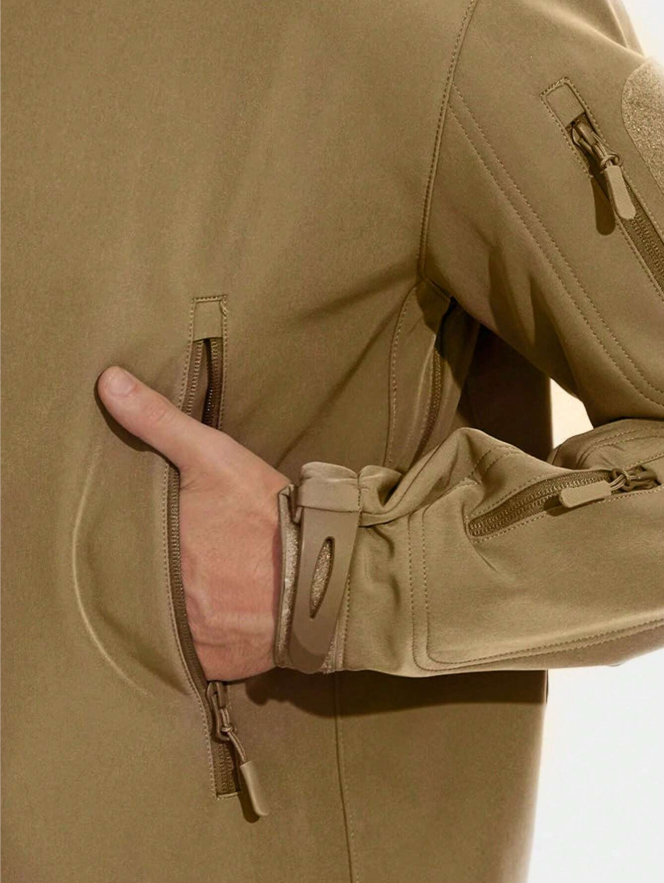 Close-up of a hand in the tan jacket's zipped side pocket, with adjustable cuff strap and sleeve pocket visible. 13