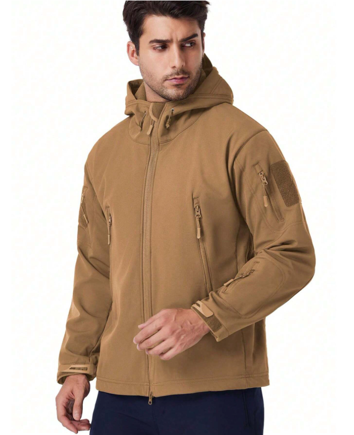 Man wearing the tan hooded jacket, front three-quarter view, showing zipped chest pockets and sleeve patch panel. 16