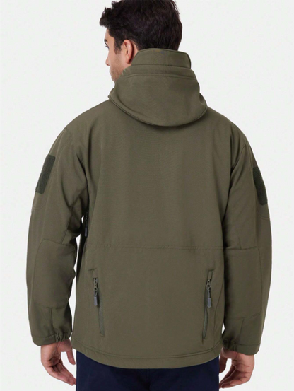 Back view of the olive green hooded jacket on a model, showing the raised hood, shoulder patches and two lower zip pockets. 5